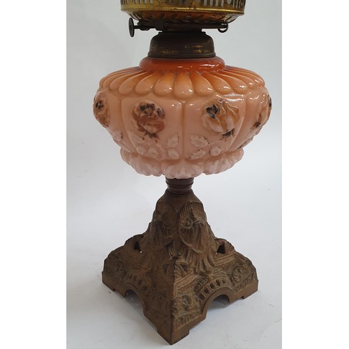 813 - A Victorian oil lamp, on pierced cast-iron plinth, with peach glass font and etched glass shade, and... 