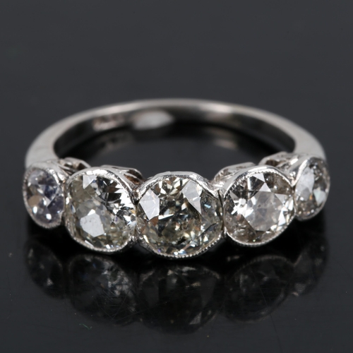 119 - A mid-20th century platinum graduated 5-stone diamond ring, bezel set with old European cut diamonds... 