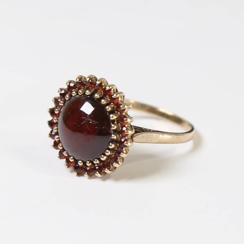 130 - A late 20th century 9ct gold garnet cluster ring, set with round cabochon garnet surrounded by round... 