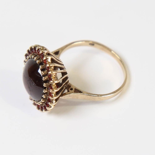 130 - A late 20th century 9ct gold garnet cluster ring, set with round cabochon garnet surrounded by round... 