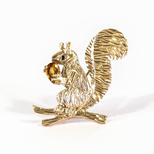 137 - A late 20th century 9ct gold figural squirrel brooch, modelled holding a pear cut citrine, with a sa... 