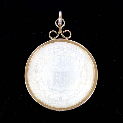 139 - A Chinese mother of pearl gaming counter pendant, in 9ct gold frame, crest decoration with 