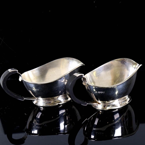 141 - A pair of George VI Art Deco silver sauce boats, stylised form with ebonised handles, by S Blanckens... 