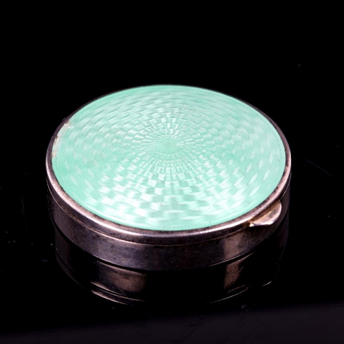 169 - An Art Deco Continental silver and green enamel compact, engine turned decoration with gilt interior... 