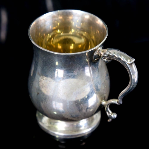 186 - A George V silver christening tankard, baluster form with scrolled acanthus leaf handle and gilt int... 