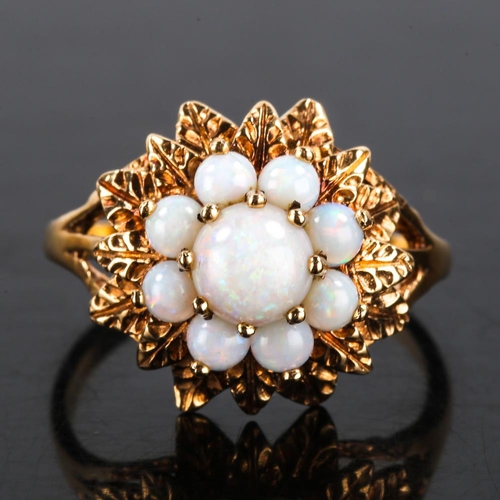 198 - A late 20th century 9ct gold opal cluster flowerhead ring, textured leaf surround set with round cab... 