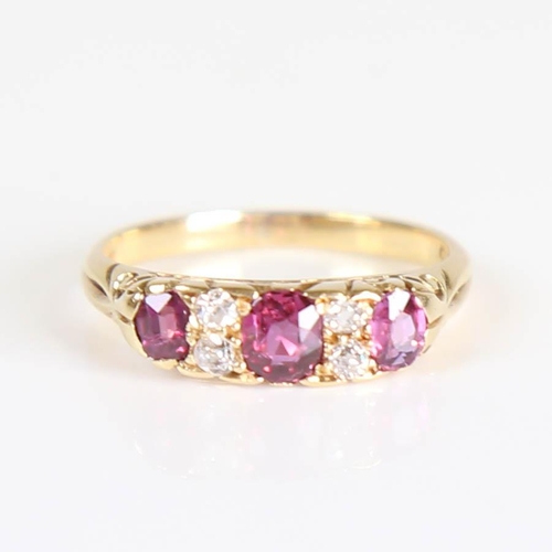 214 - An early 20th century 18ct gold 7-stone ruby and diamond half hoop ring, set with oval mixed cut rub... 