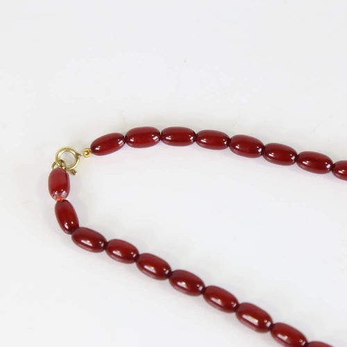 358 - A graduated single-row cherry amber bead necklace, on gilt metal clasp, beads measuring from 13.2mm ... 