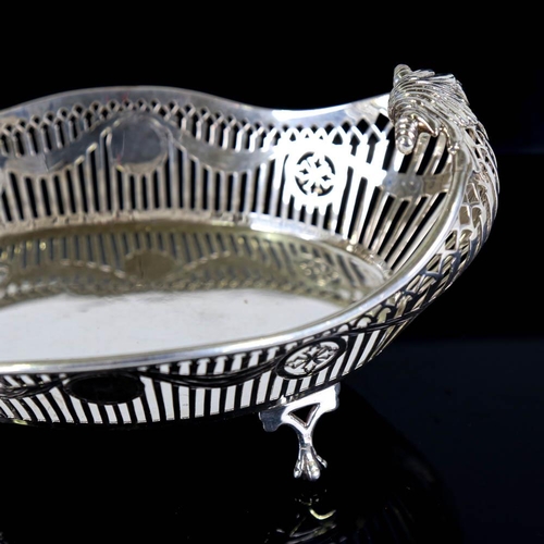 359 - A George V silver cake basket, oval form with scrolled handles, pierced gallery and engraved Adam's ... 