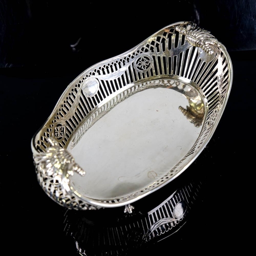 359 - A George V silver cake basket, oval form with scrolled handles, pierced gallery and engraved Adam's ... 