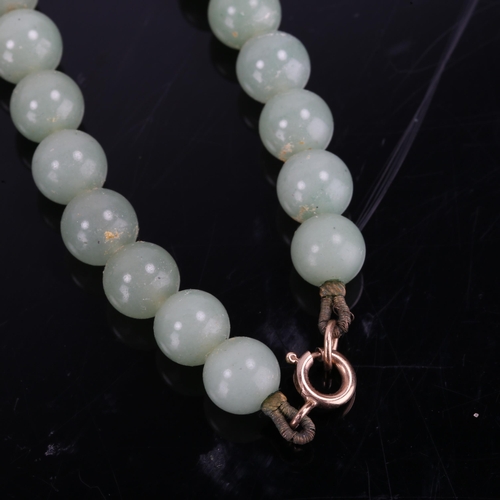 366 - A Chinese single-row polished jade bead necklace, and a similar pair of jade stud earrings, necklace... 