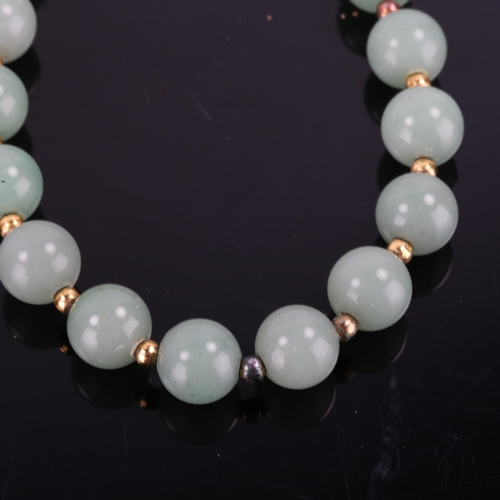 366 - A Chinese single-row polished jade bead necklace, and a similar pair of jade stud earrings, necklace... 