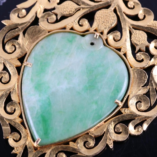 392 - A Chinese high carat gold jade heart pendant, pierced and chased foliate decoration with central pol... 