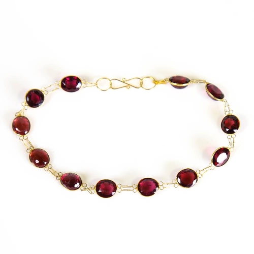 398 - A modern handmade 14ct gold garnet line bracelet, set with oval mixed cut garnets, bracelet length 1... 