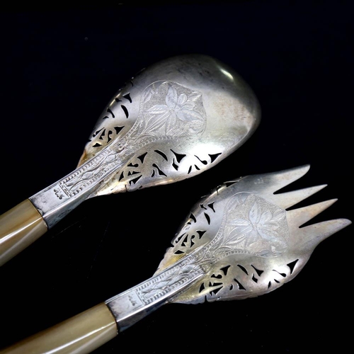 449 - A pair of Middle Eastern unmarked white metal horn-handled salad servers, engraved floral decoration... 