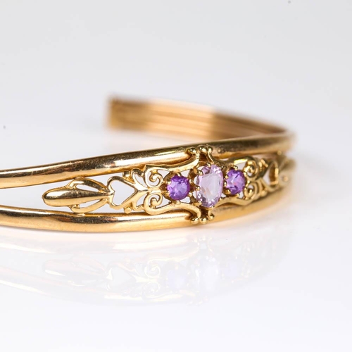 630 - A late 20th century 9ct gold amethyst cuff bracelet, pierced openwork settings with oval mixed and r... 