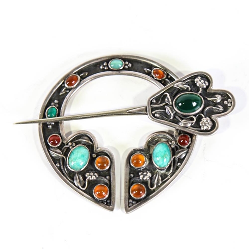 642 - A Scottish Celtic stone set penannular brooch, unmarked white metal settings with cabochon stones an... 