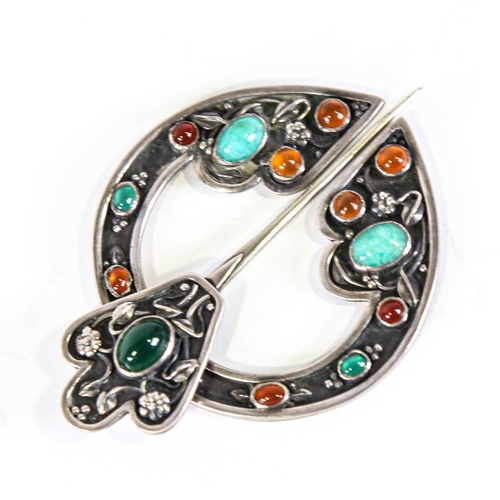 642 - A Scottish Celtic stone set penannular brooch, unmarked white metal settings with cabochon stones an... 