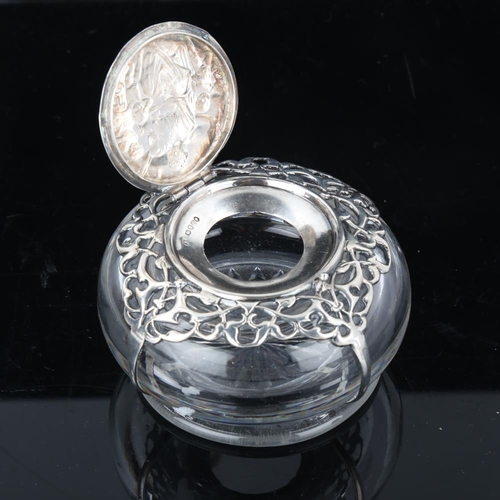 650 - A heavy Victorian silver mounted glass inkwell, relief embossed figural decoration with pierced shou... 