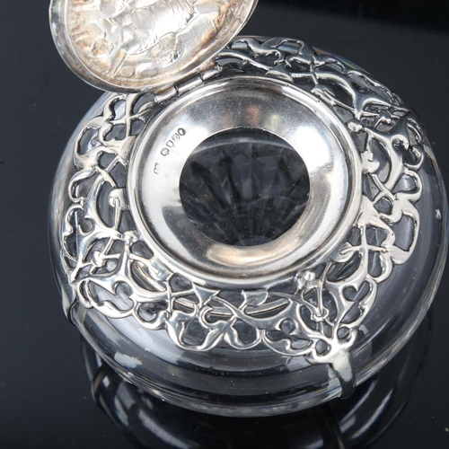 650 - A heavy Victorian silver mounted glass inkwell, relief embossed figural decoration with pierced shou... 