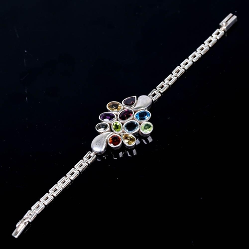 655 - A modern handmade silver gem-set bracelet, gemstones include blue topaz, garnet, amethyst, peridot, ... 