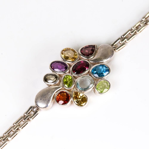 655 - A modern handmade silver gem-set bracelet, gemstones include blue topaz, garnet, amethyst, peridot, ... 