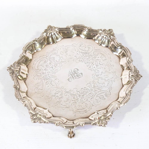 669 - A George II silver salver, circular form with foliate border and floral engraved centre, on 3 feet, ... 