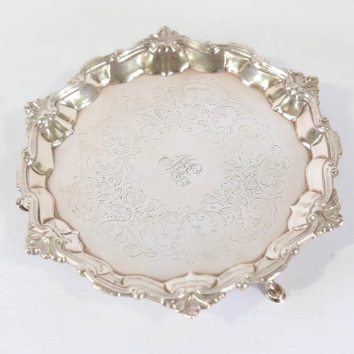 669 - A George II silver salver, circular form with foliate border and floral engraved centre, on 3 feet, ... 