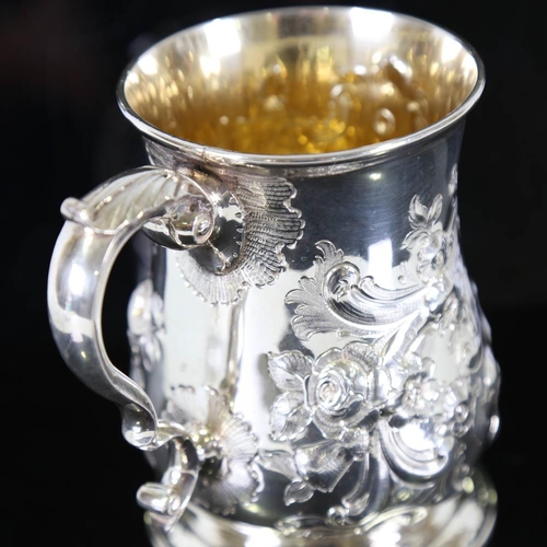 674 - *WITHDRAWN* A George II silver pint mug / tankard, relief embossed floral decoration with scrolled a... 