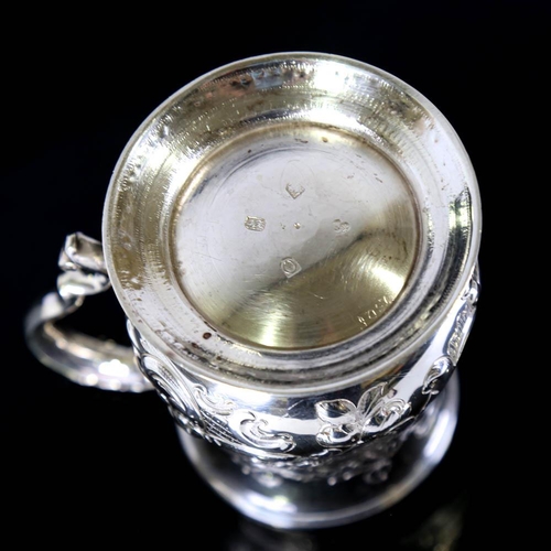 674 - *WITHDRAWN* A George II silver pint mug / tankard, relief embossed floral decoration with scrolled a... 