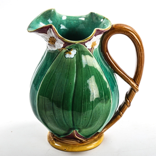 1009 - Minton Majolica pottery jug, lily flower and leaf moulded body, serial no. 1228, height 22cm