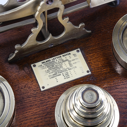 1099 - A large pair of Victorian brass parcel scales, on oak base, with original weights (2 x 4lb and set g... 