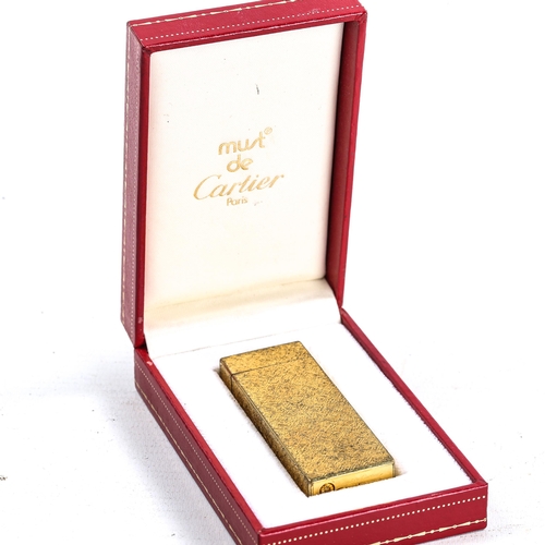 1122 - MUST DE CARTIER - a Vintage gold plated lighter, textured decoration, serial no. 09602T, height 7cm,... 