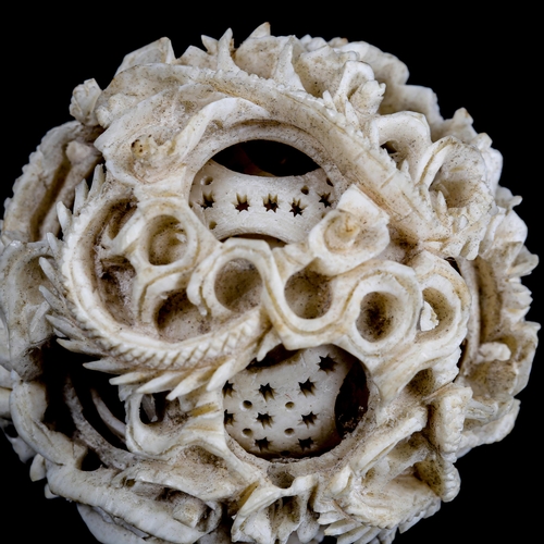 1128 - A Chinese carved ivory puzzle ball, late 19th/early 20th century, diameter 5cm