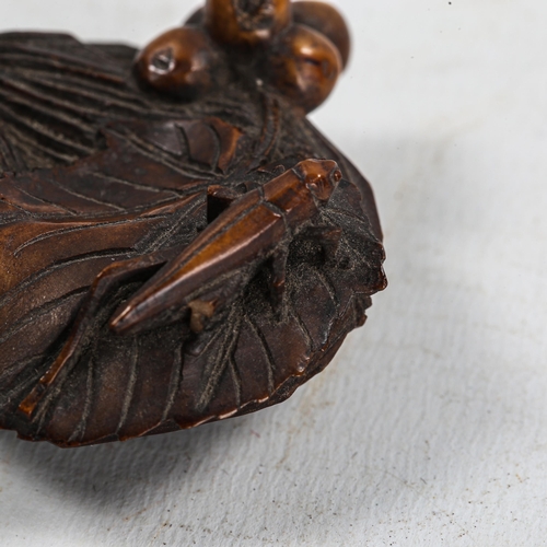 1131 - A Japanese carved wood okimono, in the form of a cricket on a corn sheath, Meiji Period, unsigned, l... 