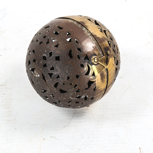 1181 - A pierced and engraved brass ball-shaped incense burner, containing a gimballed lamp, diameter 7.5cm