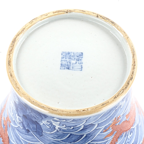 1205 - A Chinese blue and red painted porcelain vase, with dragon and sea design, seal mark, height 34cm