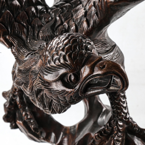 1213 - A large Japanese carved stained wood eagle on a rock, height 63cm