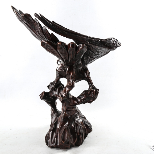 1213 - A large Japanese carved stained wood eagle on a rock, height 63cm