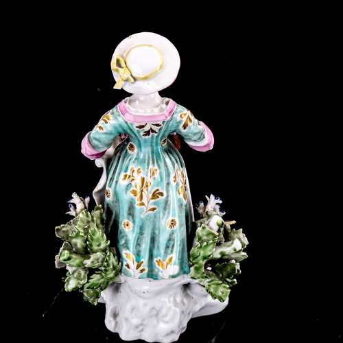 1232 - A 19th century porcelain figure, woman selling trinkets, height 15cm