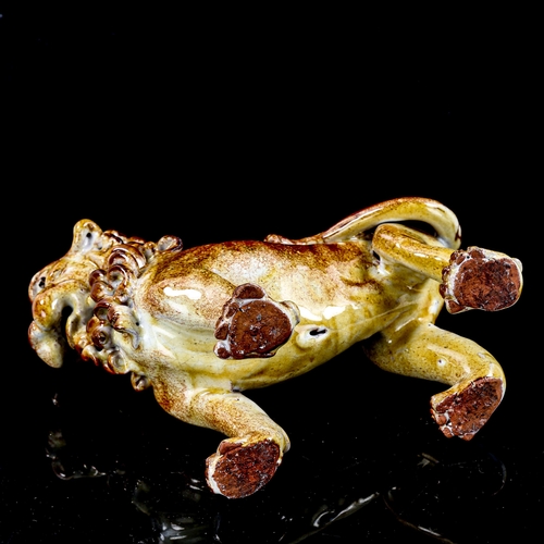 1258 - A glazed pottery standing lion figure, early 20th century, height 19cm