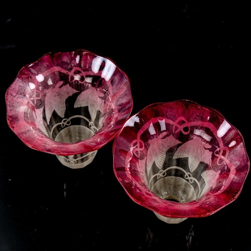 1266 - A pair of cranberry edged glass lightshades, with impressed butterfly designs, diameter 15cm