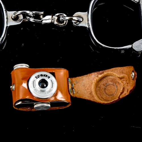 1315 - A pair of steel handcuffs and a Petie miniature camera