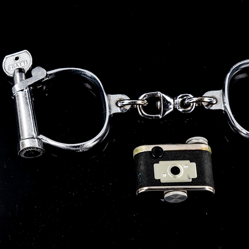 1315 - A pair of steel handcuffs and a Petie miniature camera