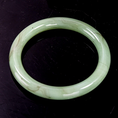 1381 - A polished jade slave bangle, band width 10mm, internal diameter 60mm, weight 46g