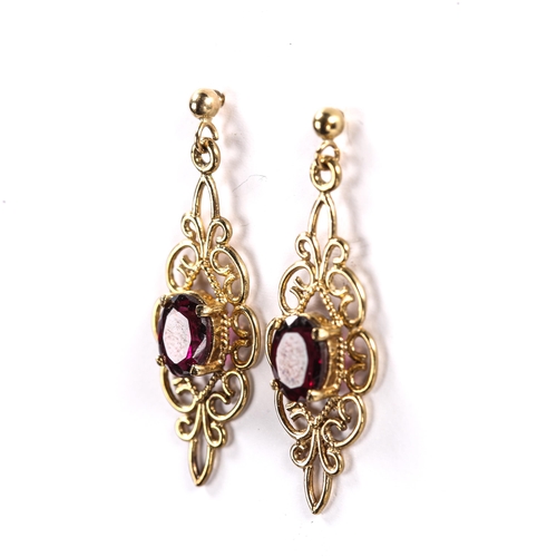 222 - A pair of modern 9ct gold garnet drop stud earrings, open wirework design with oval mixed cut garnet... 