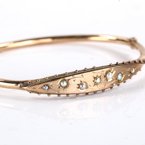 225 - An Edwardian 9ct gold split pearl and diamond hinged bracelet / bangle, engraved decoration, hallmar... 