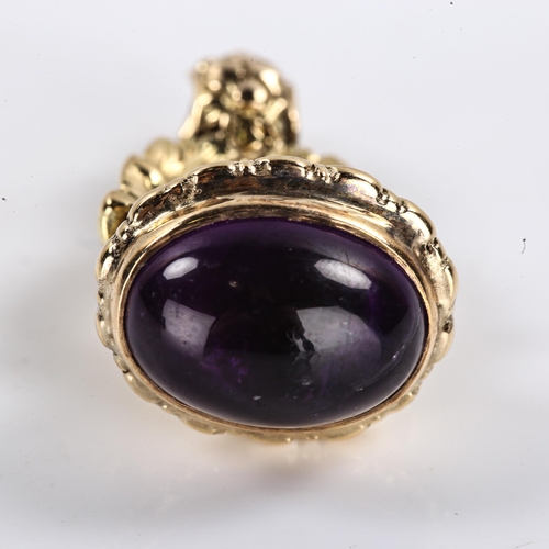 253 - An Antique cabochon amethyst fob / pendant, unmarked settings test as 9ct gold, floral openwork desi... 