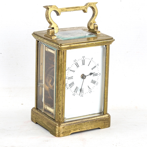 83 - A brass-cased carriage clock, white enamel dial with Roman numeral hour markers, and glass exhibitio... 