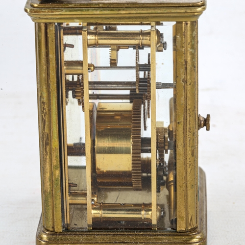 83 - A brass-cased carriage clock, white enamel dial with Roman numeral hour markers, and glass exhibitio... 